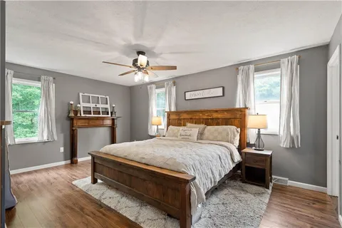 a spacious bedroom with a bed and wooden floor