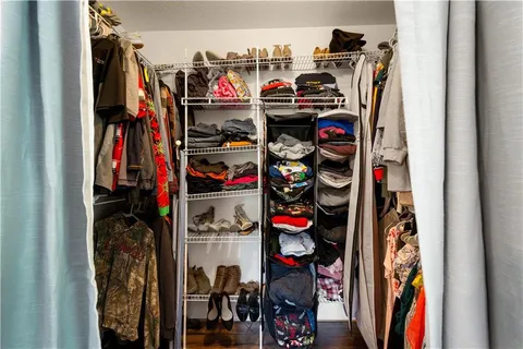 a view of walk in closet with clothes and shoes