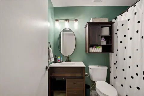 a bathroom with a sink toilet and a mirror