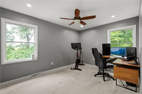 a view of a workspace with furniture and a window