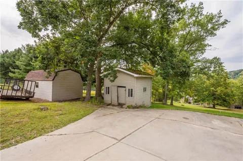 a view of a house with a yard and large tree