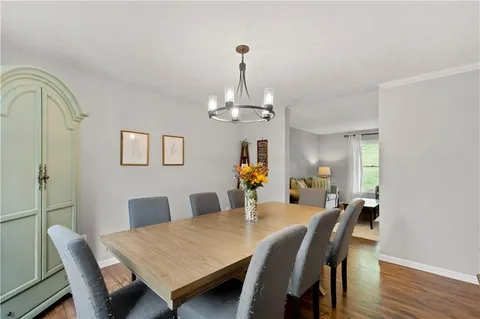 a dining room with furniture a chandelier and wooden floor