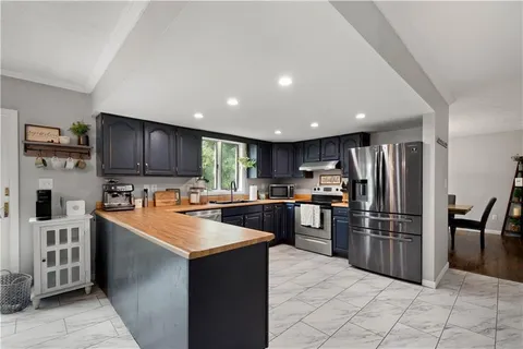 a kitchen with stainless steel appliances granite countertop a refrigerator stove and oven