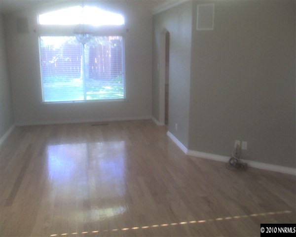 6319 Chesterfield Lane Reno, NV 89523 - Photo 5 of 8 an empty room with wooden floor and windows