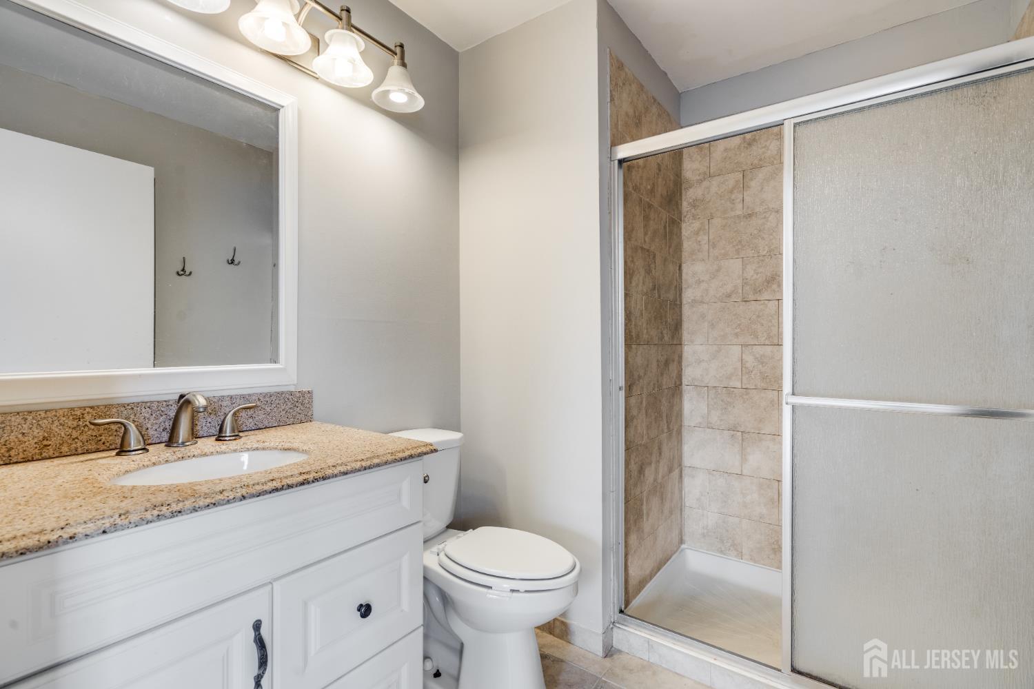 304 Wimbeldon Court North Brunswick, NJ 08902 - Photo 9 of 19 a bathroom with a granite countertop sink toilet and shower