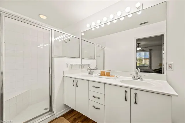 a bathroom with a double vanity sink mirror and shower
