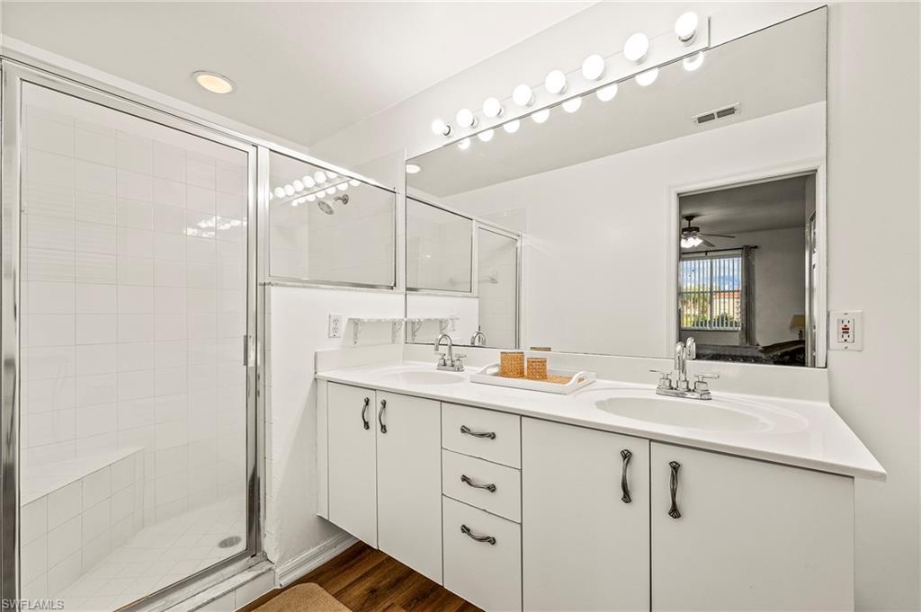 280 Robin Hood Circle, Unit 101 Naples, FL 34104 - Photo 13 of 19 a bathroom with a double vanity sink mirror and shower