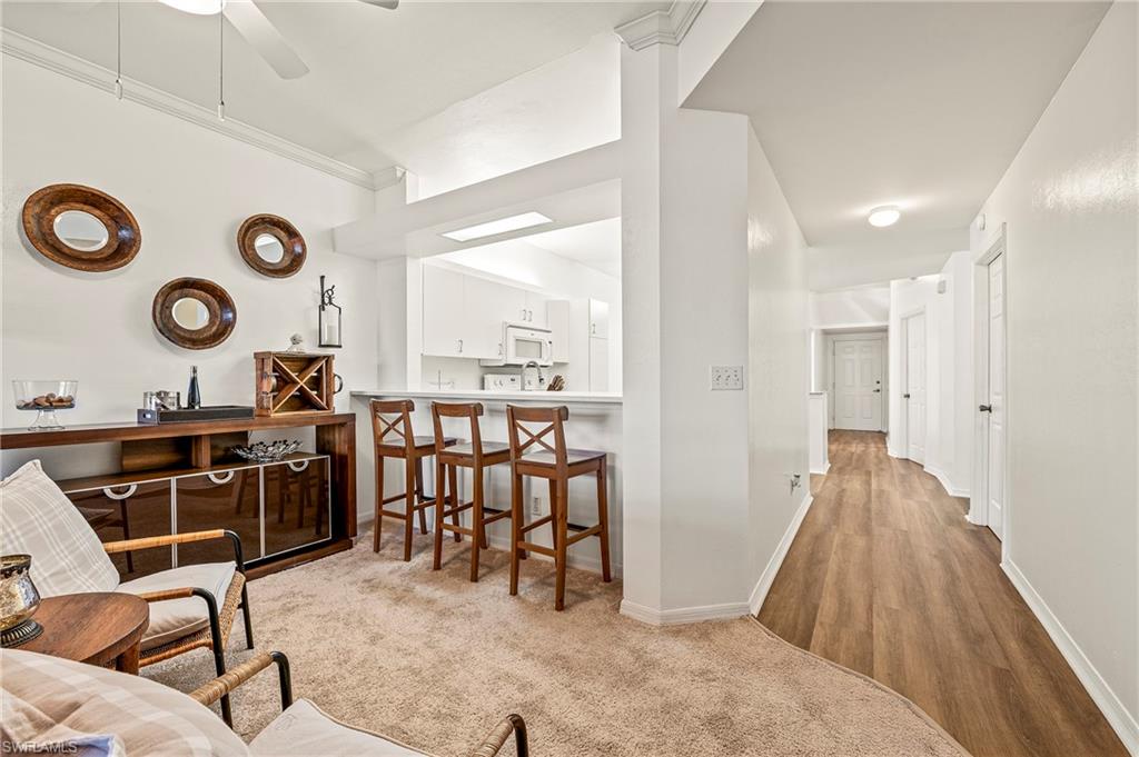 280 Robin Hood Circle, Unit 101 Naples, FL 34104 - Photo 4 of 19 a view of a kitchen and a dining table chair