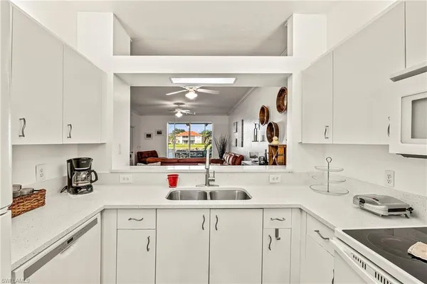 a kitchen with sink cabinets and white appliances