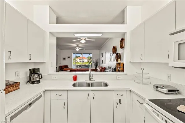 a kitchen with sink cabinets and white appliances