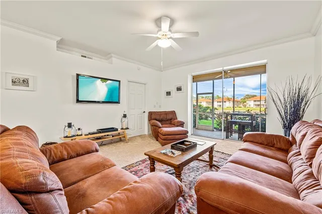 a living room with furniture a large window and a flat screen tv