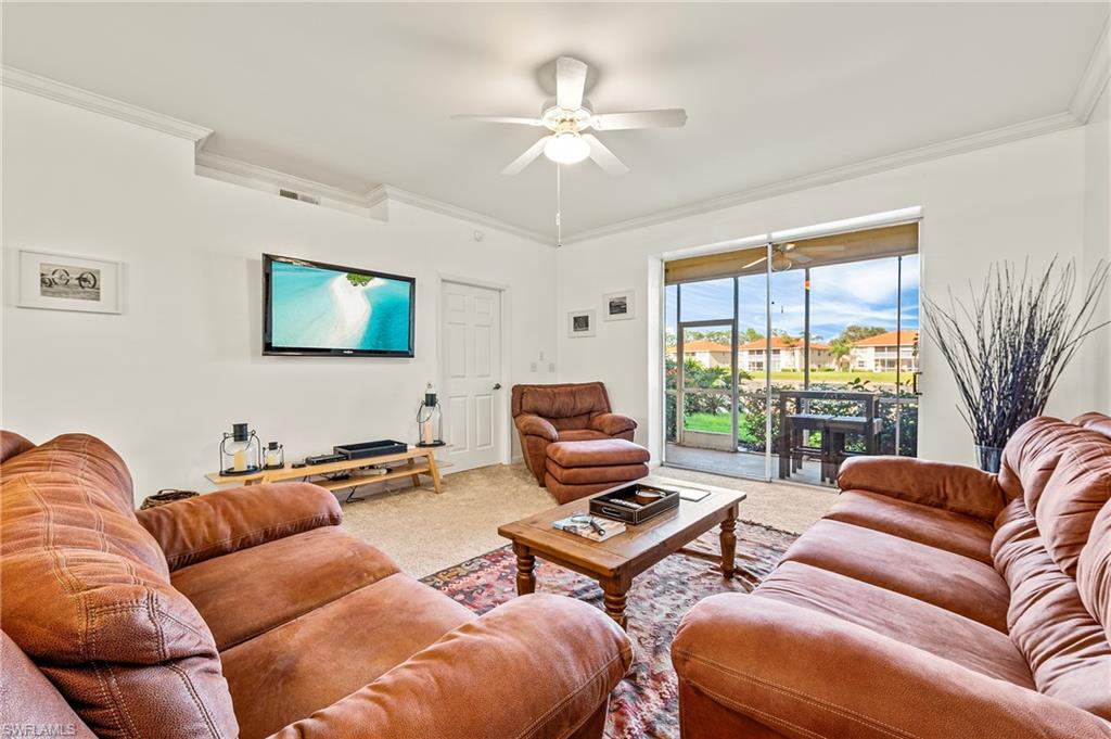 280 Robin Hood Circle, Unit 101 Naples, FL 34104 - Photo 7 of 19 a living room with furniture a large window and a flat screen tv