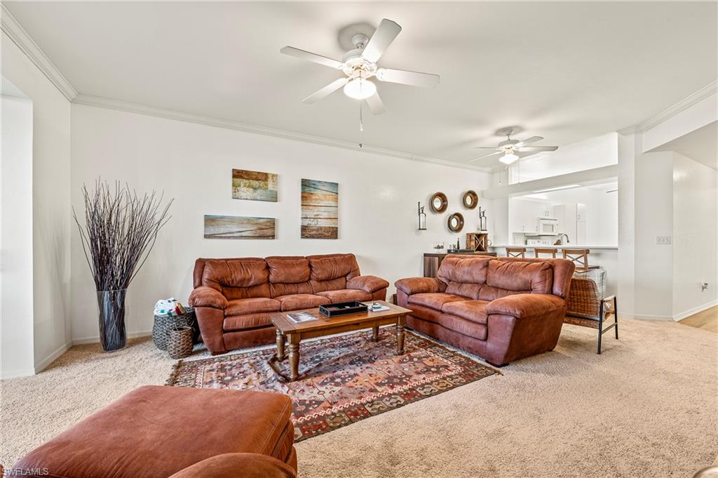 280 Robin Hood Circle, Unit 101 Naples, FL 34104 - Photo 10 of 19 a living room with furniture and a chandelier