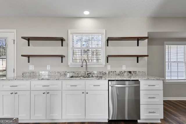 a kitchen with granite countertop a sink cabinets and window