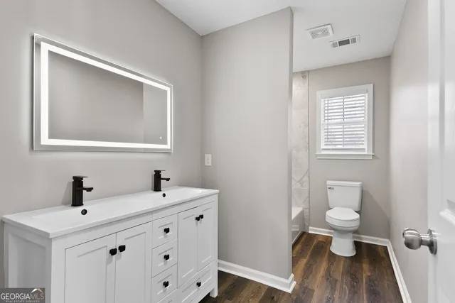a bathroom with a sink a toilet and a mirror