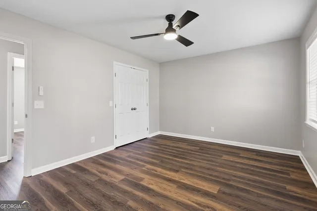a view of empty room with wooden floor