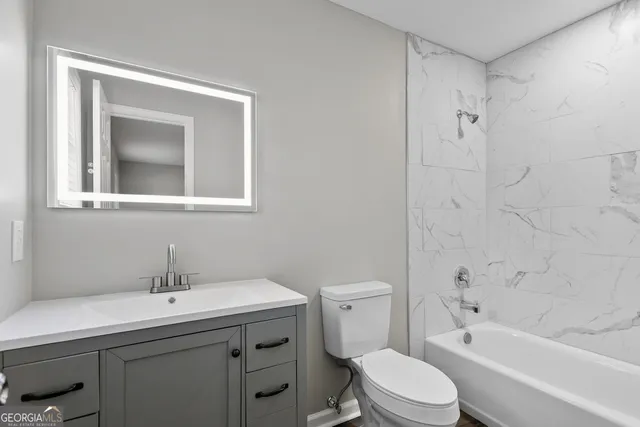 a bathroom with a toilet a sink a mirror a bathtub and shower