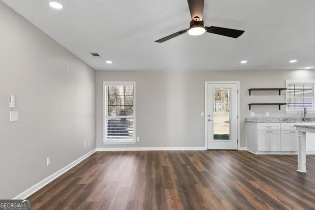 a view of a kitchen with a sink and dishwasher with wooden floor
