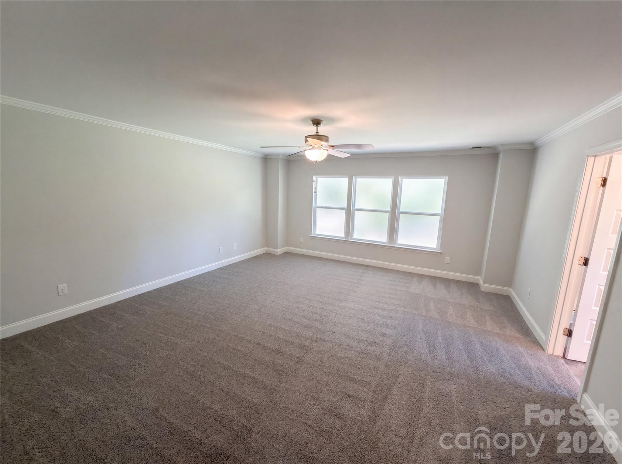 4918 Griffith Road Monroe, NC 28112 - Photo 4 of 17 an empty room with windows and chandelier fan