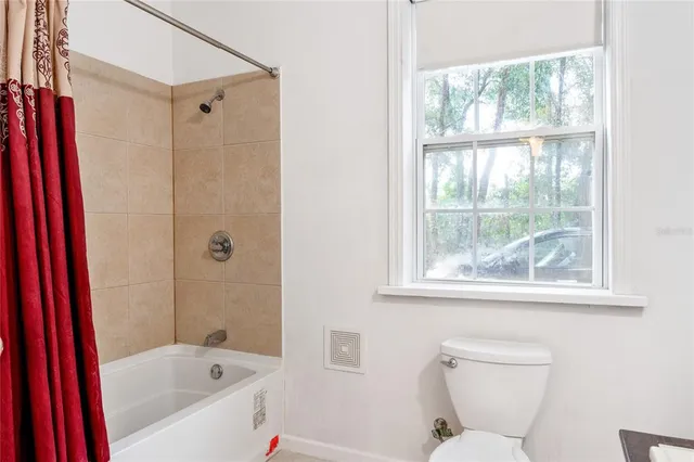 a hallway with a view of living room and wooden floor