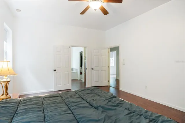 a bedroom with a bed and hardwood floor