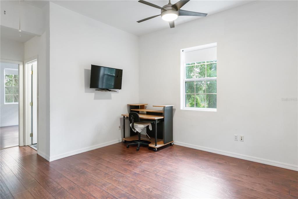 16295 Highway 40 Ocala, FL 34481 - Photo 35 of 39 an empty room with wooden floor a ceiling fan and windows