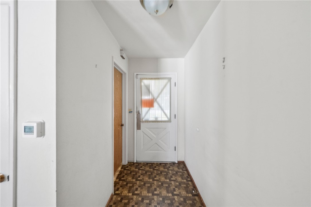 5433 Rochester Street Riverside, CA 92504 - Photo 17 of 29 Interior hallway with parquet-style flooring and an exterior door at the end.