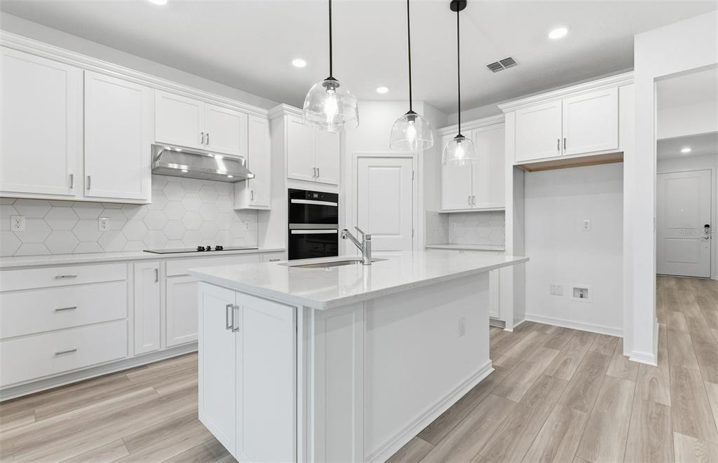 8339 Southwest 58 Loop Ocala, FL 34481 - Photo 2 of 35 a kitchen with white cabinets and stainless steel appliances