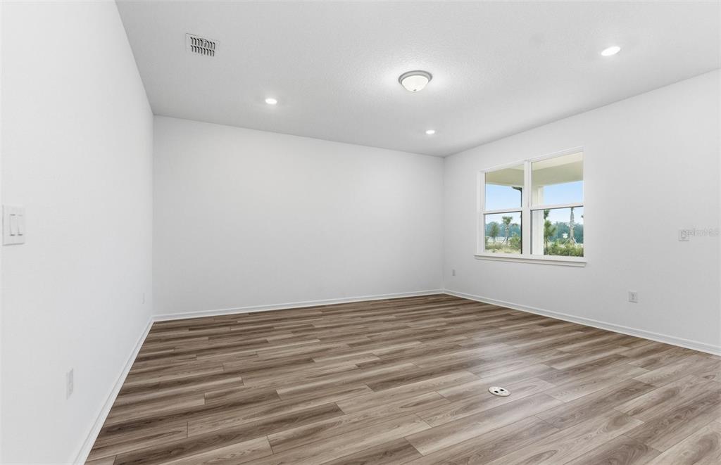 8339 Southwest 58 Loop Ocala, FL 34481 - Photo 5 of 35 an empty room with wooden floor and windows