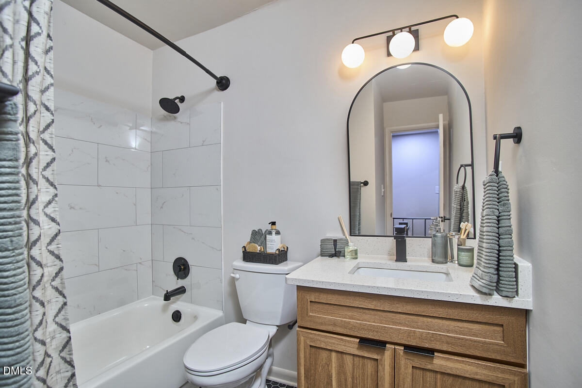 2613 McNeil Street, Unit B Raleigh, NC 27608 - Photo 25 of 31 a bathroom with a sink toilet a mirror and shower