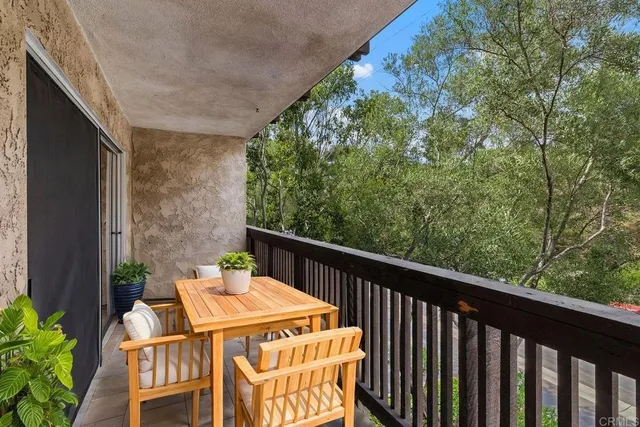 a balcony with wooden floor table and chairs