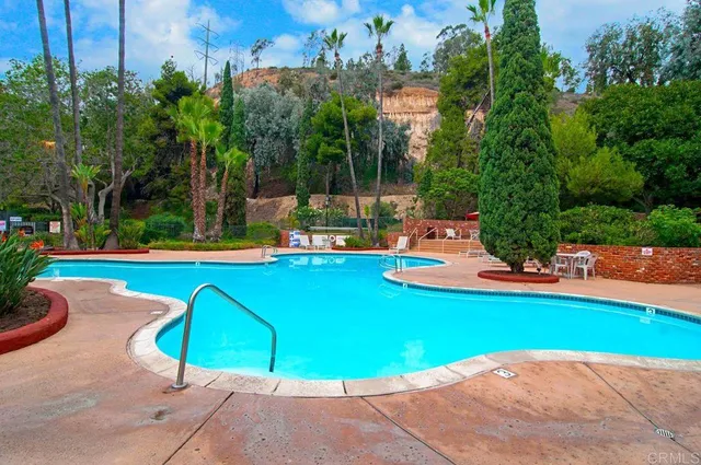 a view of a swimming pool with a bench and trees
