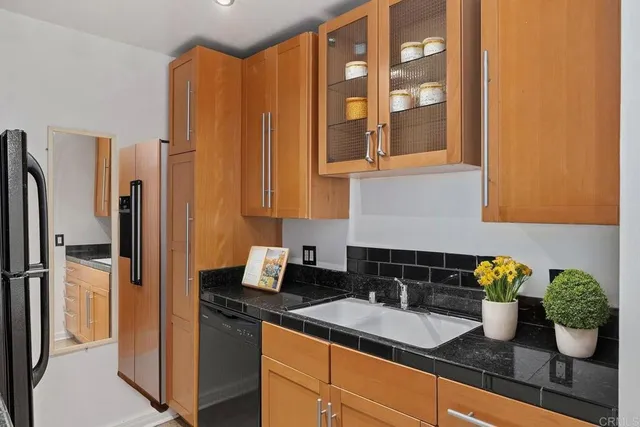 a kitchen with stainless steel appliances granite countertop a refrigerator a sink a stove and white cabinets