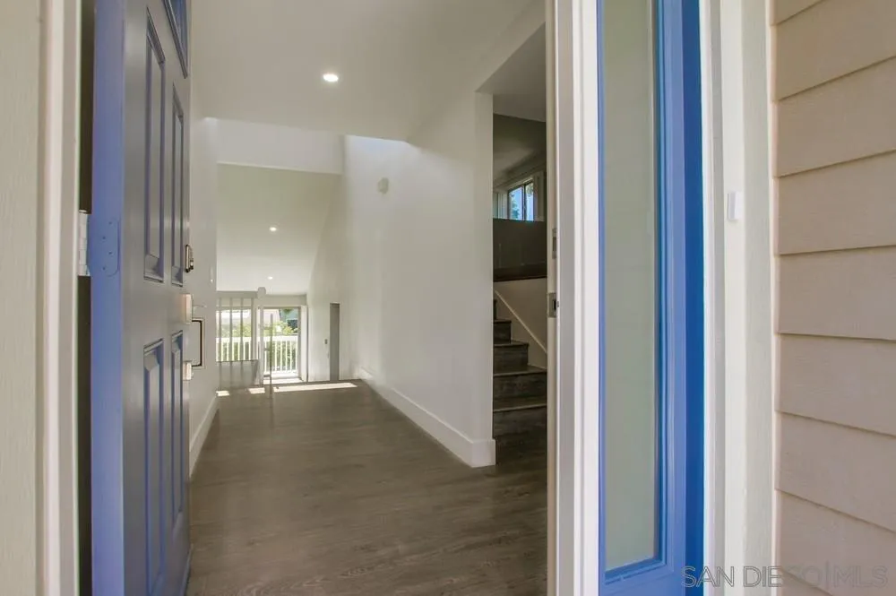 1764 Whitehall Road Encinitas, CA 92024 - Photo 4 of 25 a view of a hallway with a dining room with chandelier
