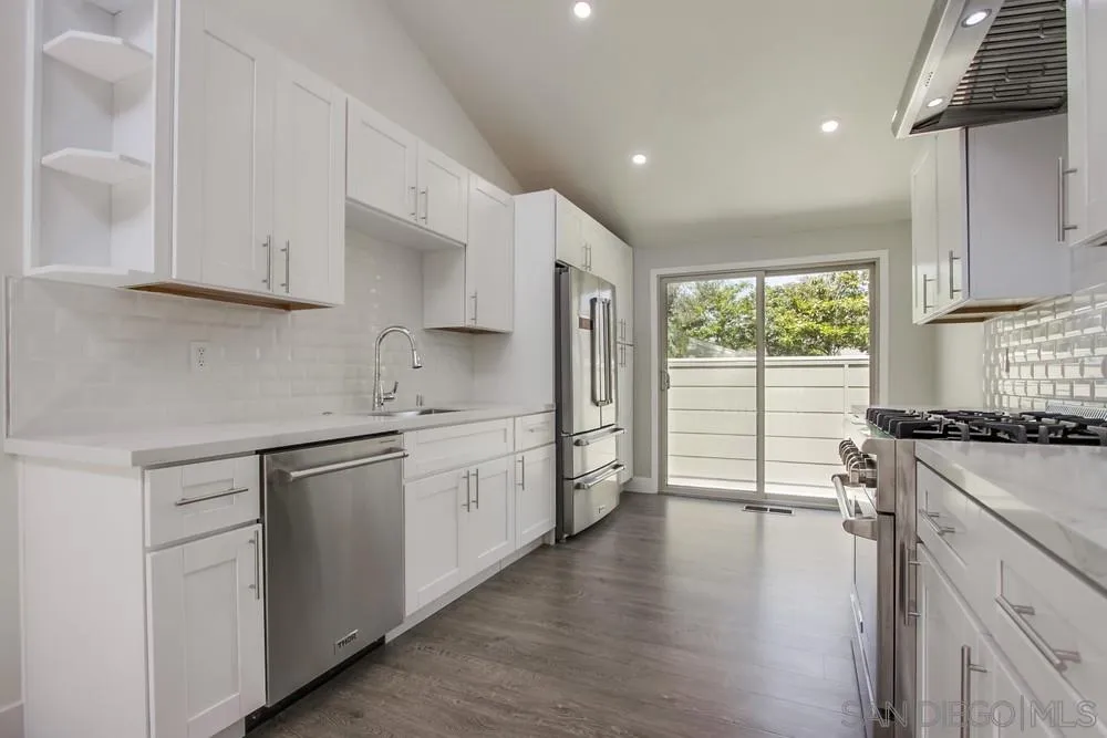 1764 Whitehall Road Encinitas, CA 92024 - Photo 6 of 25 a kitchen with a stove a sink and white cabinets with wooden floor