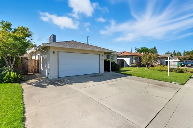 a front view of a house with a yard and trees