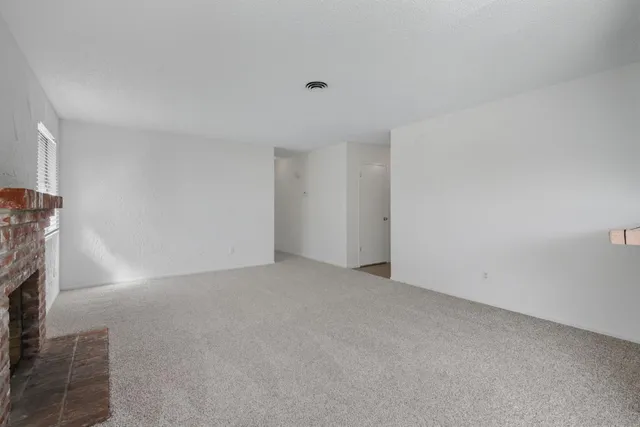 a view of an empty room with a fireplace