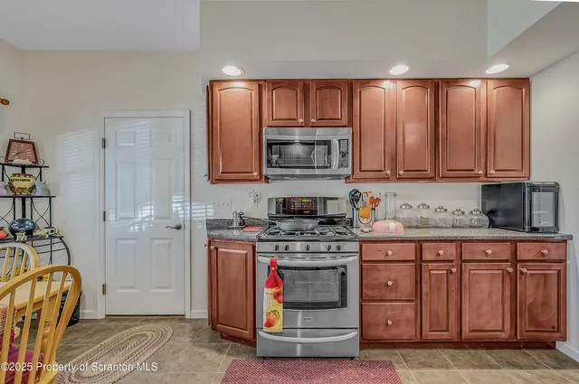 a kitchen with stainless steel appliances granite countertop a stove and cabinets