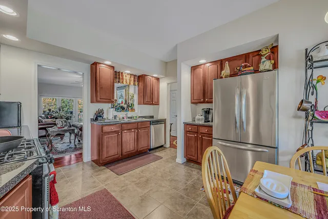a kitchen with stainless steel appliances granite countertop a refrigerator and a stove