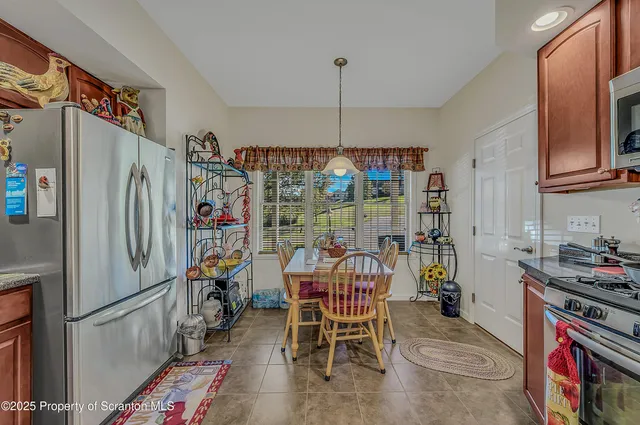 a kitchen with stainless steel appliances granite countertop a refrigerator and a wooden cabinets