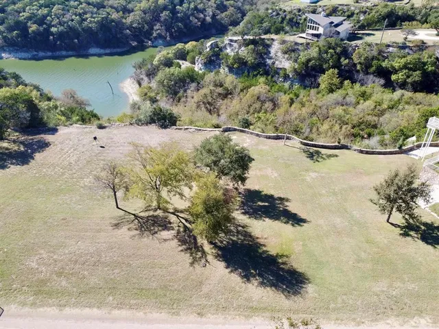 a view of a dry yard with wooden fence