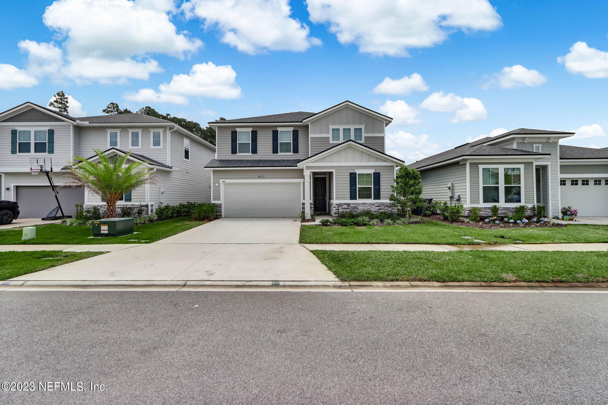 a front view of a house with a yard and potted plants