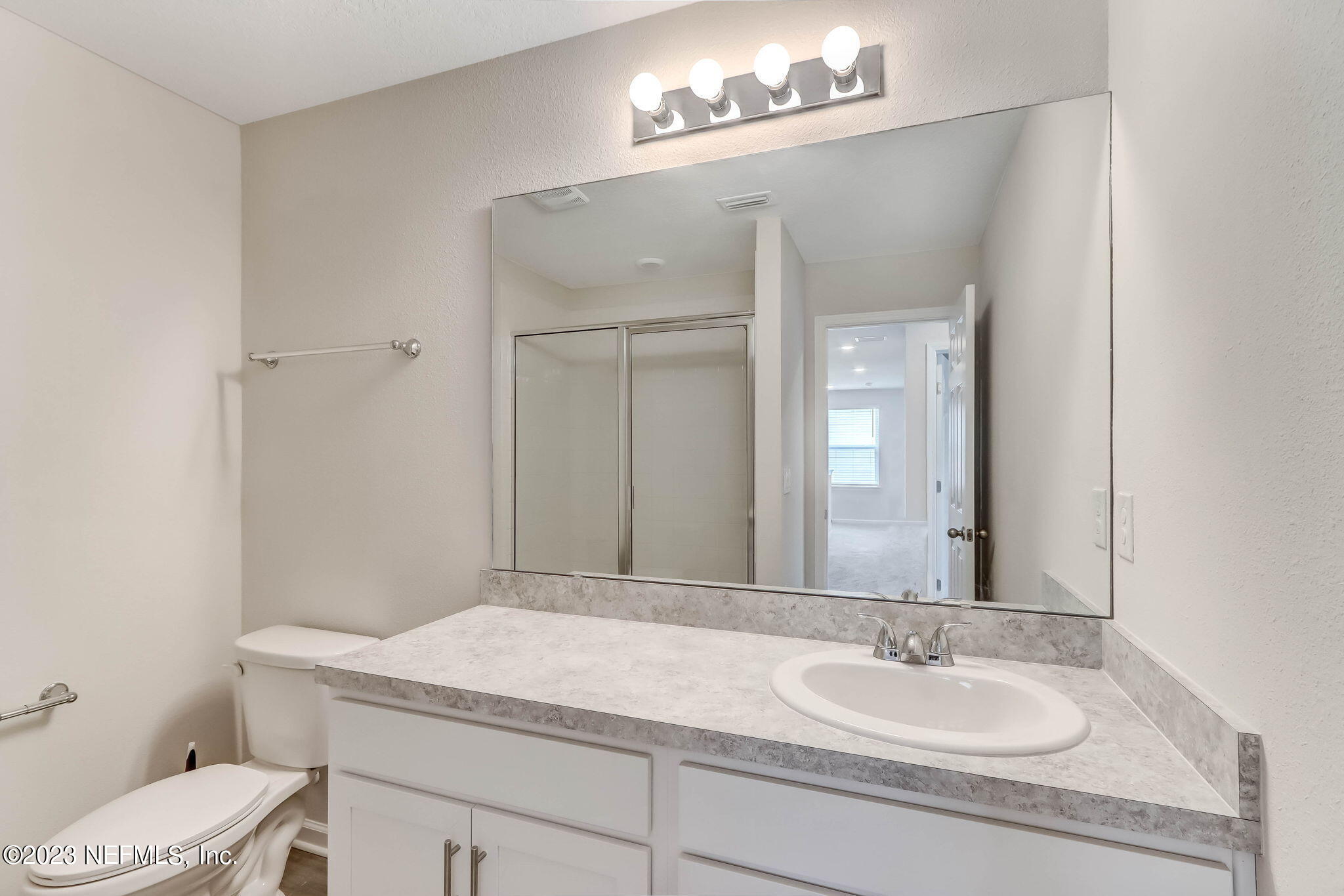 75944 Saffron Lane Yulee, FL 32097 - Photo 27 of 79 a bathroom with a granite countertop sink a toilet and a mirror