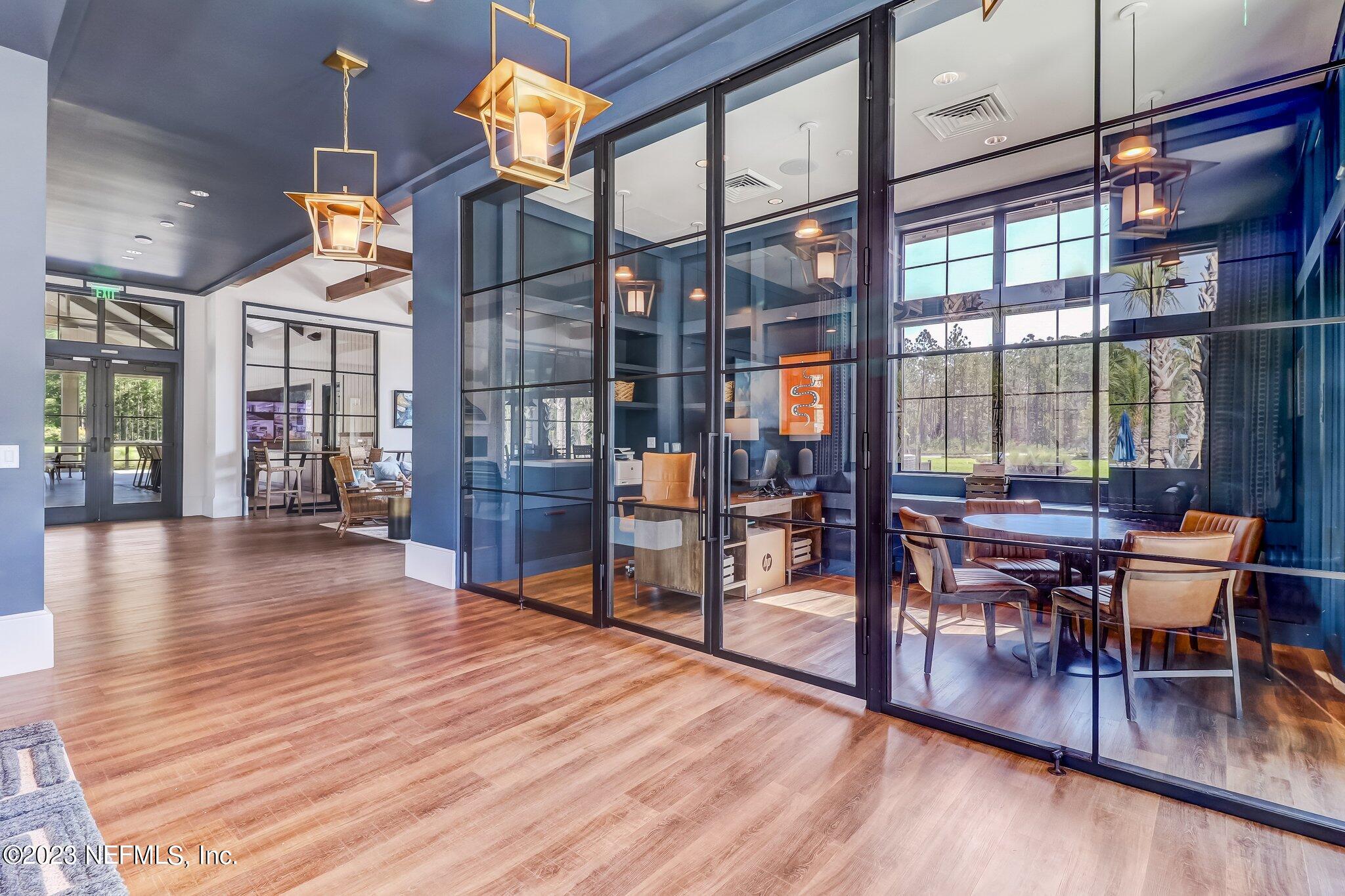 75944 Saffron Lane Yulee, FL 32097 - Photo 65 of 79 a dining room with wooden floor a glass table and chairs