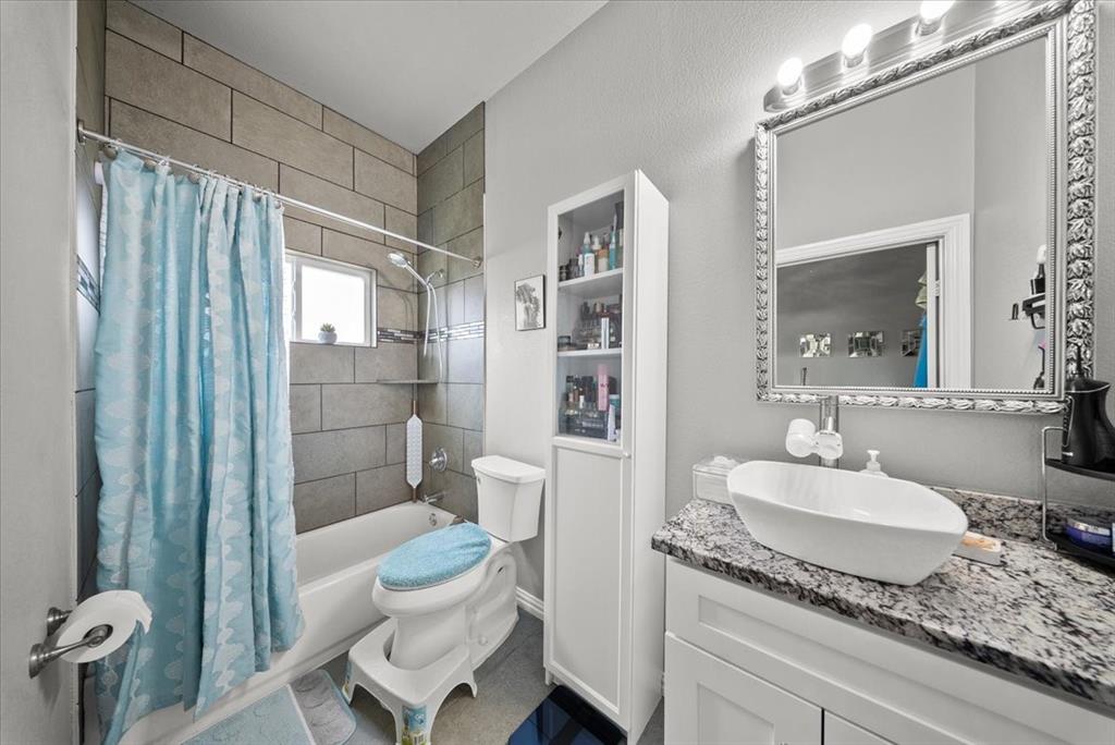 5312 Black Hawk Street Dallas, TX 75212 - Photo 14 of 24 a bathroom with a granite countertop sink a toilet a mirror and shower