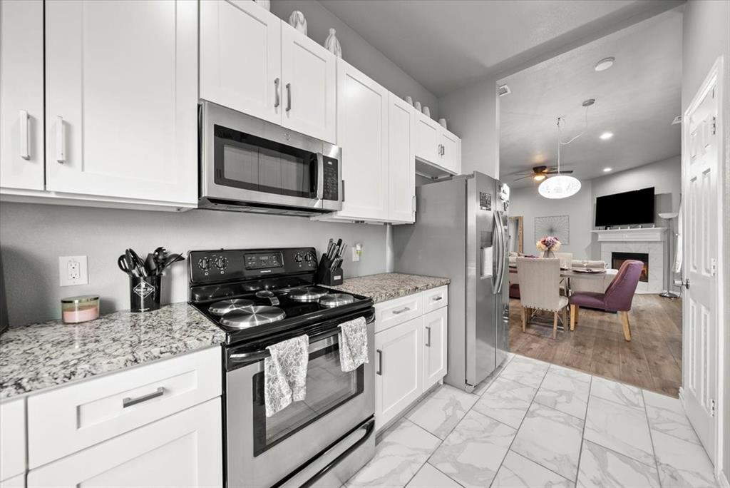 5312 Black Hawk Street Dallas, TX 75212 - Photo 10 of 24 a kitchen with stainless steel appliances granite countertop a stove a sink and a microwave