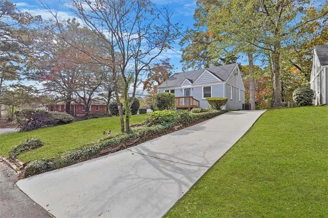 a front view of a house with a yard and trees
