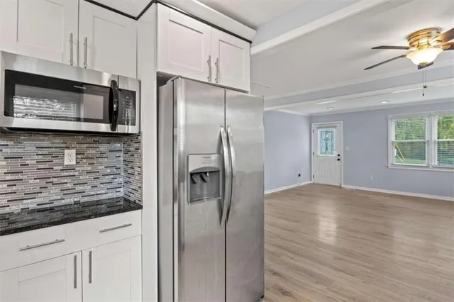 a kitchen with stainless steel appliances granite countertop a refrigerator and a microwave