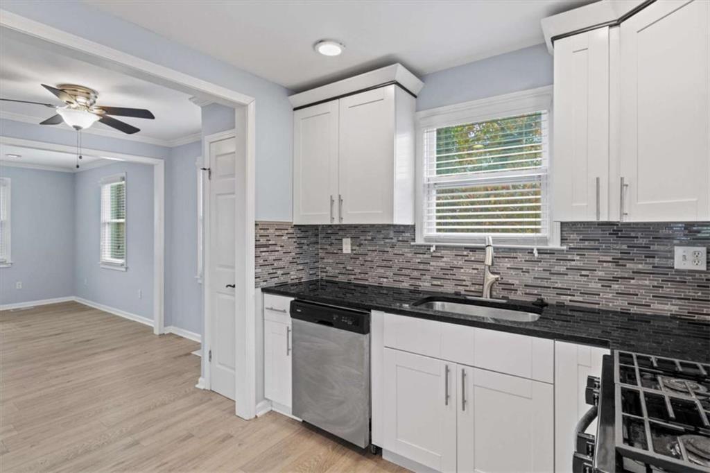 701 Daniel Avenue Decatur, GA 30032 - Photo 28 of 37 a kitchen with granite countertop a stove a sink and dishwasher with wooden floor