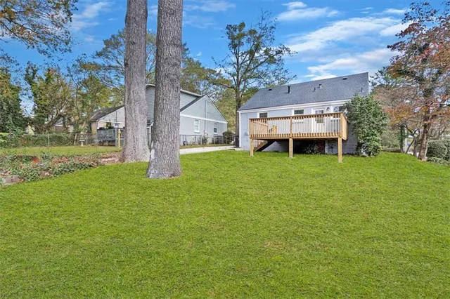 a view of a house with a big yard and large trees
